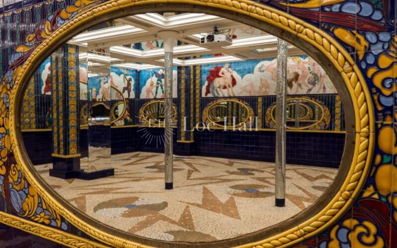 Un grand miroir Art déco orné de mosaïques dans la salle de réception « Aux Belles Poules ».